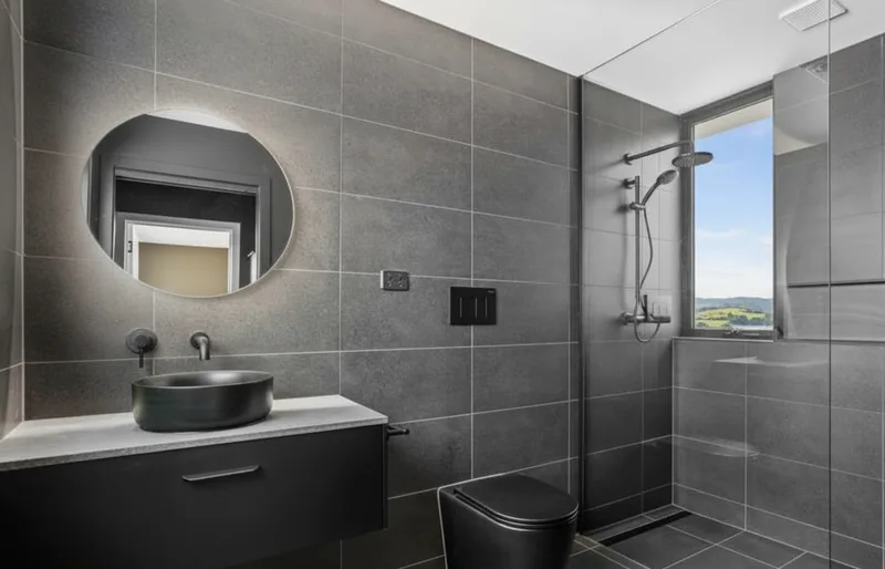 A modern designer bathroom with a frameless walk-in shower and clean tiled joints